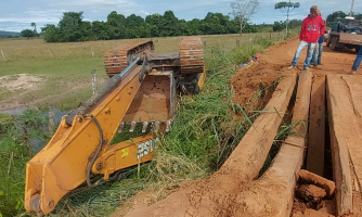 Ponte quebra e máquina pesada cai de caminhão prancha na Zona Rural